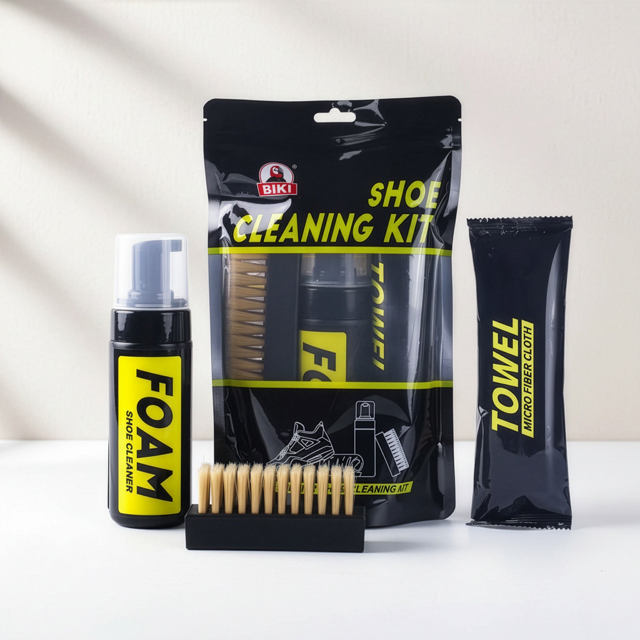Shoe cleaning kit with foam, brush, and towel on a white background